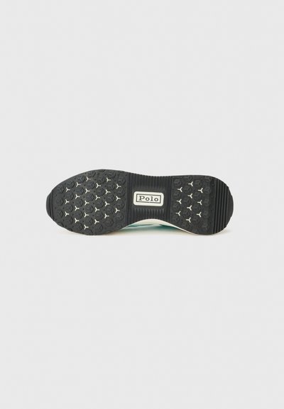 Talpa de sneaker din cauciuc negru, cu un model de prindere hexagonal, având un eticheta albă "Polo" în centrul său și un toc neted, ușor ridicat.