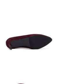 Zapato de tacón de ante burdeos con punta afilada y suela de goma negra. Textura suave con un diseño elegante y minimalista.