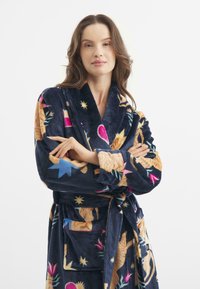 Accappatoio in pile con sfondo blu navy, decorato con vivaci motivi floreali e celesti. Include una chiusura con cravatta e tasche laterali.
