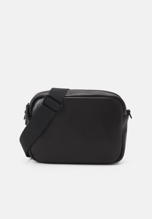 Black rectangular crossbody bag with adjustable fabric strap and zippered top closure on a white background.