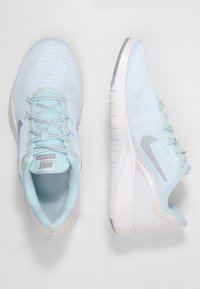 Jasnoniebieskie buty biegowe Nike z przewiewną siateczką, teksturowaną podeszwą i srebrnym logo, wyposażone w system sznurowania oraz wyściełany kołnierz.