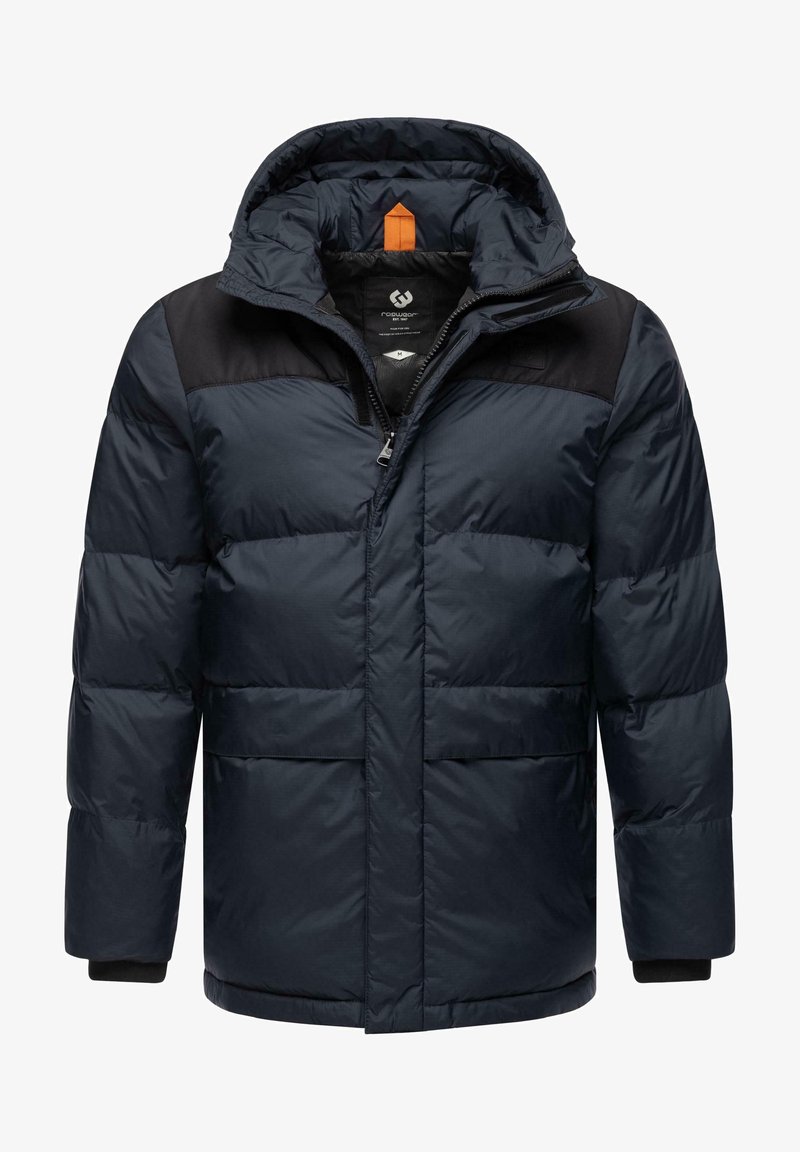 Tumši jūras zila pūkainā jaka ar melnu augšējo daļu, kapuci, priekšējo rāvējslēdzēju un divām lielām kabatām. Piedāvā papildu oranžus akcentus pie apkakles.