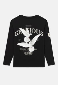 Sort langærmet skjorte med to hvide duer, stor "GRACIOUS" tekst, mindre tekst, stregkode og mærke på venstre ærme.