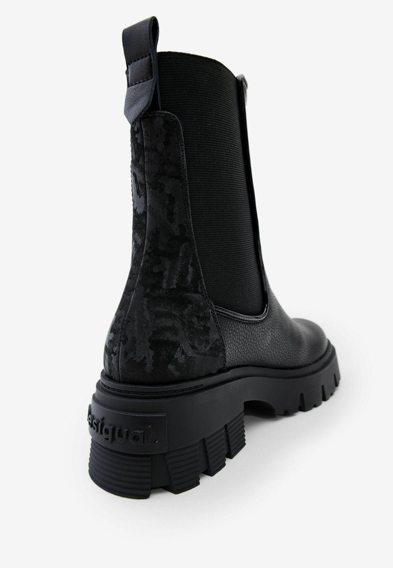 Stivale Chelsea nero con tomaia testurizzata, elastico laterale, suola in gomma spessa e logo impresso sul tallone.