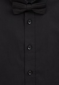 Chemise formelle noire avec un nœud papillon, au tissu lisse, col classique et six boutons noirs sur le devant.
