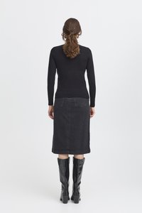 Haut noir à manches longues, jupe midi en denim gris foncé et bottes noires montant jusqu'aux genoux. Textures lisses et design minimaliste.