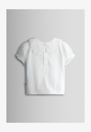 Wit shirt met korte mouwen, een kanten kraag met geschulpte rand en een inzetstuk met drie knopen. Zachte stof met geplooide mouwen, minimalistisch ontwerp.