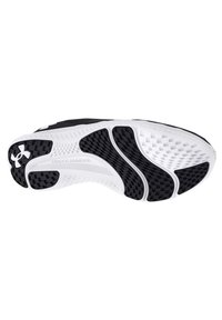 Suola di scarpa sportiva in bianco e nero con gomma testurizzata per aderenza, molteplici scanalature flessibili e marchio 'Under Armour' lungo il lato.