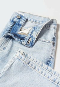 Light blue denim jeans featuring a zip fly, button closure, and visible stitching details. The fabric has a faded wash with a soft texture.