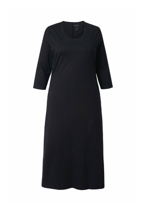 Černé šaty dlouhé ke kolenům, vyrobené z měkké látky, s výstřihem do oblouku a rukávy tři čtvrtě. Mají rovný střih a žádné viditelné vzory.