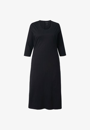 Czarna sukienka do kolan z miękkiego materiału, z dekoltem w łódkę i rękawami do połowy przedramienia. Charakteryzuje się prostą sylwetką i brakiem widocznych wzorów.