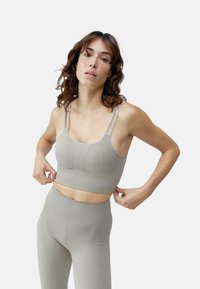 Lichtgrijze geribbelde sportbeha met verstelbare dunne banden, voorzien van een aansluitend ontwerp en subtiele textuur, gecombineerd met bijpassende high-waisted legging.