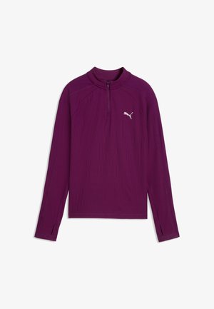 Lilla sportstrøje med lange ærmer med kvart-lynlås i kraven, hul til tommelfingrene i ærmekanterne og hvid Puma-logo på venstre bryst.