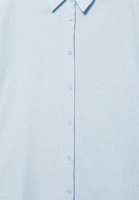 Chemise bleu clair à manches longues avec col et sept boutons blancs sur le devant, en tissu texturé.