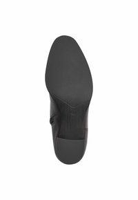 Suola di scarpa in pelle nera caratterizzata da una superficie testurizzata e gommata, con una forma arrotondata e sottili dettagli di cucitura. Taglia contrassegnata come 37.
