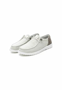 Zapatos slip-on de color gris claro con parte superior de tela texturizada, suela de goma blanca y un acento marrón en el talón. Presenta detalle de cordones.