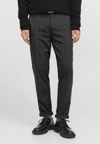 Pantaloni grigi a scacchi realizzati in tessuto, con una vestibilità slim, fronte piatto e orli arrotolati, abbinati a scarpe nere con lacci.