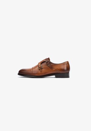 Chaussure habillée en cuir marron avec deux boucles, bout rond et un petit talon noir. Texture lisse avec une finition polie et des détails de couture minimaux.