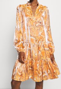Orange marble-patterned dress with a V-neck and long puff sleeves. The design features a tiered hem and a smooth, flowing texture.