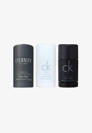 Tre cylindriske deodoranter: sort til "Eternity," hvid til "CK One," og sort til "CK Be," alle mærket med produktnavne og detaljer.