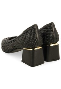 Zapatos de cuero trenzado negro con tacón cuadrado que presentan una puntera cuadrada y un acento en tono dorado en el tacón. Superficie texturizada con un patrón detallado.