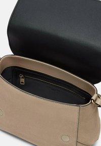 Borsa in suede beige con patta in pelle nera, dotata di una tasca con zip all'interno e dettagli in metallo dorato. Texture liscia con bordi arrotondati.