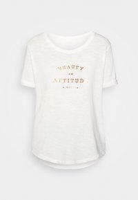 Weißes Kurzarm-T-Shirt mit rundem Halsausschnitt. Verfügt über metallisch goldene Buchstaben, die "SCHÖNHEIT ist eine EINSTELLUNG" von Roxy lesen. Weiche Textur.