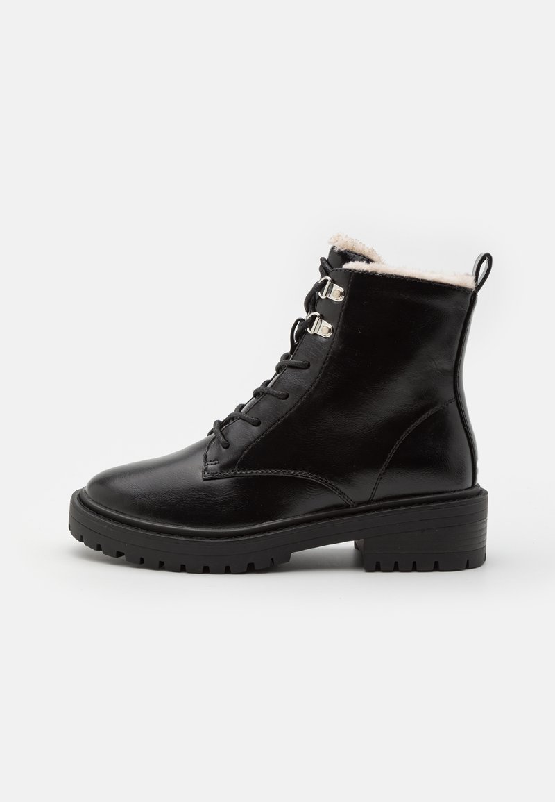 Bottes de cheville en cuir noir avec une finition lisse, un design à lacets, une doublure en polaire et une semelle robuste pour l'adhérence. Elles sont dotées d'accents en quincaillerie argentée.