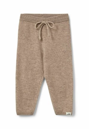 Pantalon en maille beige avec taille et poignets côtelés, doté d'un cordon noué et d'une petite étiquette en bas de la jambe gauche.