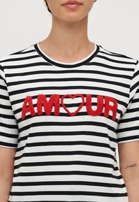 Randig t-shirt i svart och vitt med röd texturerad brodyr som stavar "AM♥UR" över bröstet. Klassisk rund halsringning och korta ärmar.