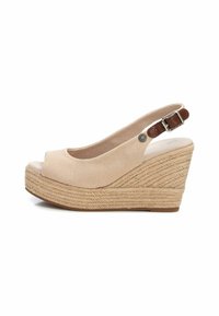 Sandalia de cuña de lona beige con tira trasera y acento de cuero marrón. Presenta una suela intermedia de yute tejido y un diseño de puntera abierta.