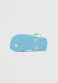 Talpa de flip-flop din cauciuc albastru deschis, cu textură nervurată. Prezintă două unghiuri circulare de prindere de culoare albastru închis și o curea verde atașată pe laterale.
