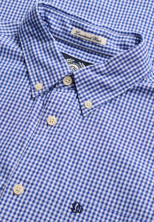 Niebiesko-biała koszula w kratę typu button-down z zapiętym kołnierzykiem oraz małym haftowanym logo na kieszeni na piersi.