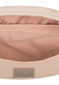 Ljusrosa tygpåse med en slät inredning. Har ett dragkedjestängning och en grå etikettlapp med logotyp på framsidan.