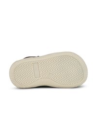 Suela de zapato con una parte inferior de goma beige que presenta un patrón de espiga, puntera redondeada y una marca mínima en la superficie texturizada.