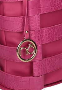 Borsa a tracolla rosa con un design testurizzato, dotata di manici lisci e con stampa a croco. Include un ciondolo circolare in oro attaccato.