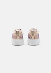 Baskets avec une semelle blanche, une languette et un talon beige effet suédé. La tige présente un motif multicolore en strass. Logo "GUESS" sur le talon.