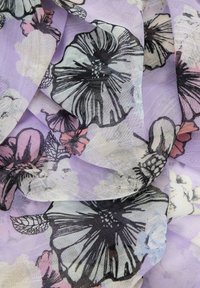 Tessuto leggero e trasparente con sfondo lavanda che presenta motivi floreali neri e pastello. Texture morbida con drappeggio fluido.