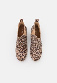 Bottines à imprimé léopard avec une texture douce, bout arrondi et panneaux latéraux élastiques pour un enfilage facile. Motif de couleur marron et noir.