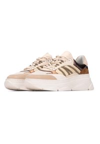 Beige sneakers met een geprofileerde mesh bovenkant, met taupe accenten en zwarte strepen, op een chunky witte zool. Vetersluiting met een gewatteerde kraag.