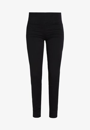 Zwarte leggings van een gladde, rekbare stof, met een brede, elastische tailleband en een slanke pasvorm die naar de enkels toe smaller wordt. Geen zichtbare sluitingen.