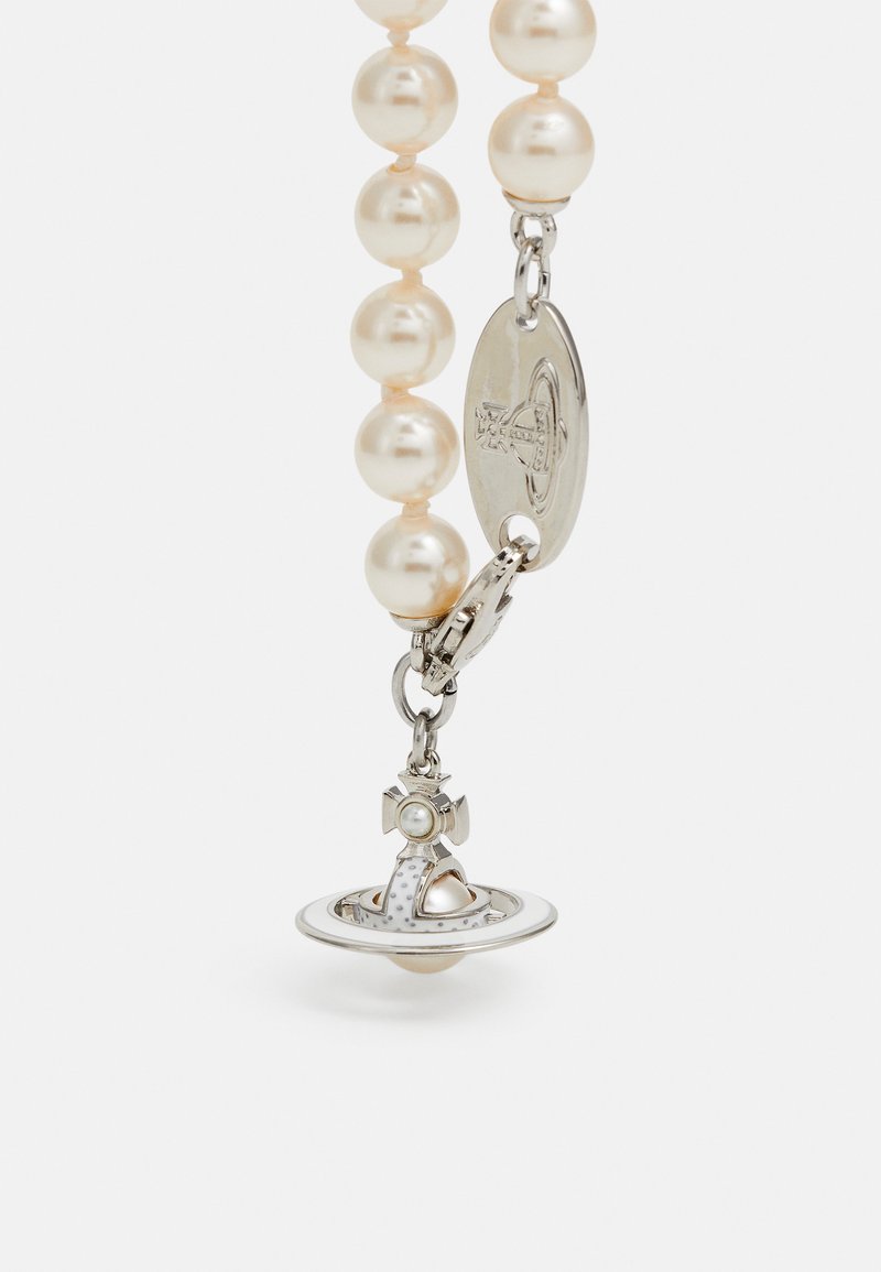 Accessorio in perle con attacco color argento e charm a forma di pianeta, dettagli intricati e perlina centrale.