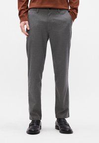 Grå skræddersyede bukser med en glat tekstur, lige pasform og sidelommer. Sættes sammen med sorte dressko.