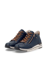 Paire de baskets en cuir bleu marine avec des lacets marron, des fermetures éclair latérales, des semelles blanches et des collerettes rembourrées à la cheville sur fond blanc.