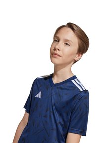 Maglietta sportiva a maniche corte di colore blu navy con un motivo geometrico, design a V e strisce bianche Adidas sulle spalle.