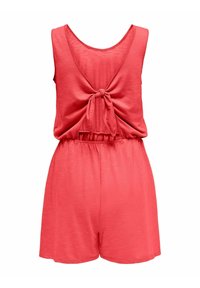 Rompère sans manches corail avec une conception à dos noué, une taille élastique et une texture douce. Le short est ajusté et arrive à mi-cuisse.
