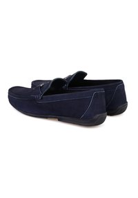 Dunkelblaue Wildlederslipper mit einer abgerundeten Spitze, kontrastierenden Nähten und einer flexiblen Gummisohle. Praktisches Slip-On-Design mit niedrigem Profil.