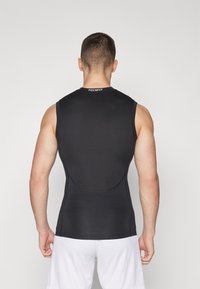 Black sleeveless compression shirt with a smooth texture, featuring a round neck and flat seams. Logo visible on the back collar.