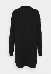 Pull en maille noire avec une texture côtelée, un col rond haut et des manches longues. Dispose d'une coupe décontractée et de petites fentes sur les côtés à l'ourlet.