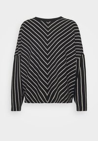 Suéter blanco y negro con un patrón de chevron, con mangas largas, un corte relajado y un escote redondo. Tejido de punto texturizado.
